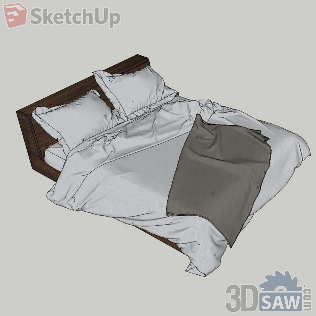 Walnut platform bed with a rumpled white duvet and a grey throw laid across it