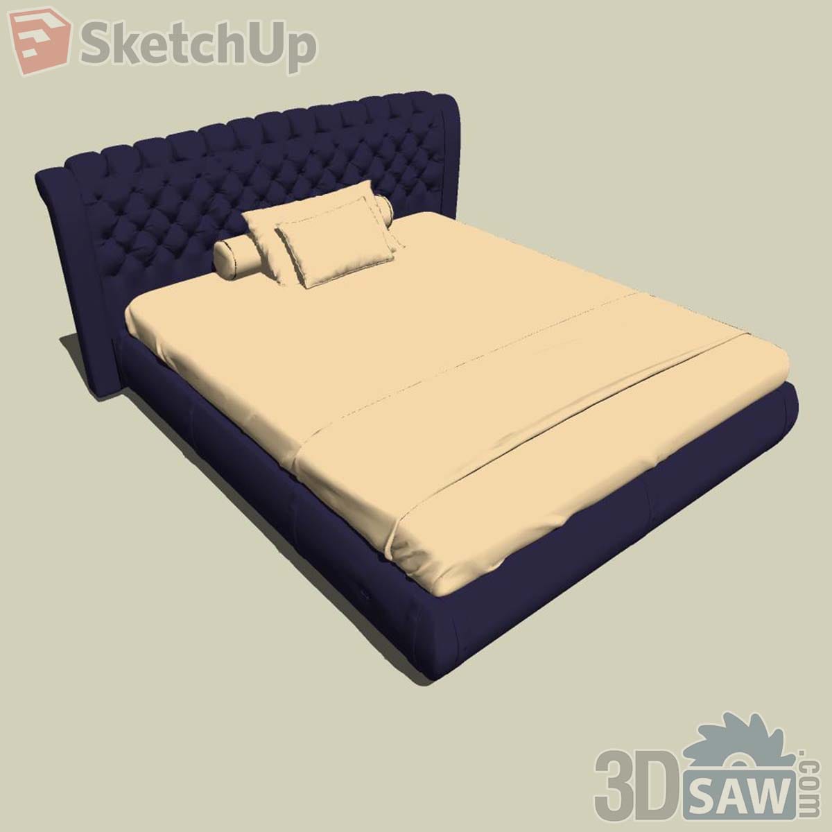 Navy Chesterfield-style bed with diamond-tufted curved headboard and pale yellow bedding